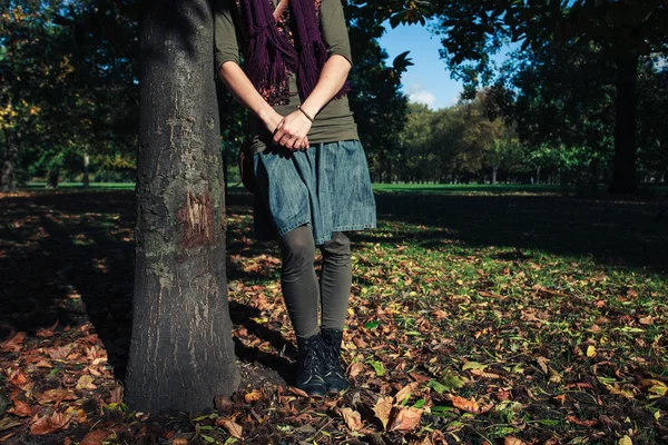 年轻女人站在秋天里的一棵树 — 图库照片