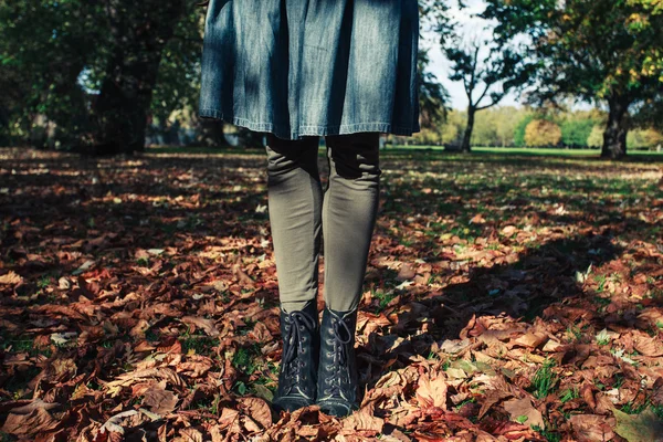 Jovem mulher de pé em folhas — Fotografia de Stock