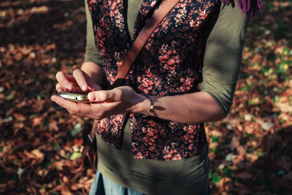 Kobieta za pomocą jej telefon w parku — Zdjęcie stockowe