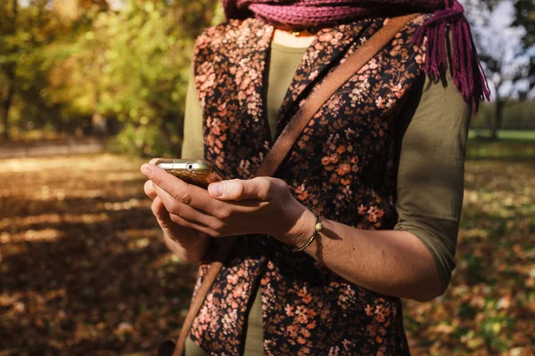 女性が公園で彼女の電話を使用して — ストック写真