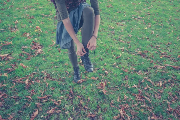 Woman tying her shoe in the park — Stock Photo, Image