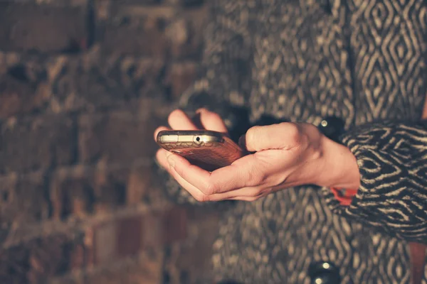 Молодая женщина пользуется телефоном на закате — стоковое фото