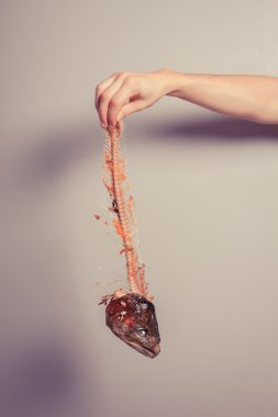 Balık iskeleti tutan el