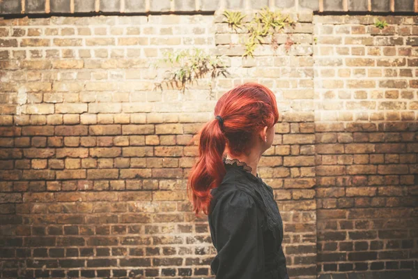 年轻的红头发女人走在巷子里 — 图库照片