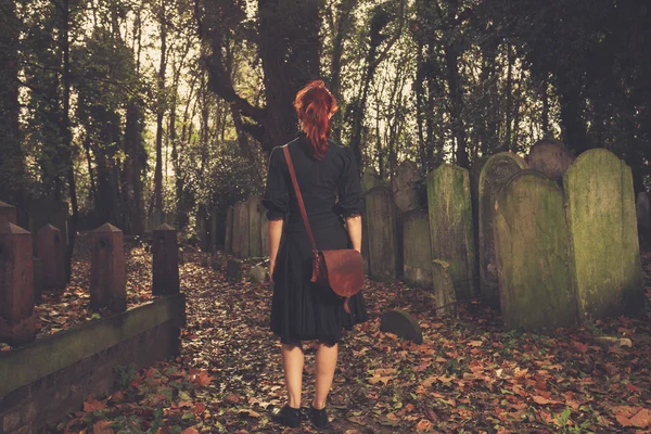 Femme marchant parmi les pierres tombales — Photo