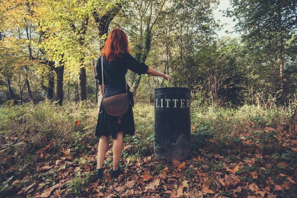 Женщина убирает мусор в лесу — стоковое фото