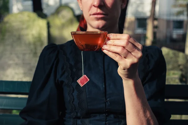 Woman drinking tea on cemetery — Stock Photo, Image