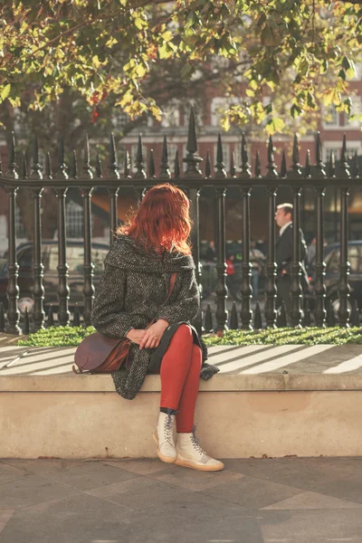Молодая женщина сидит в парке — стоковое фото