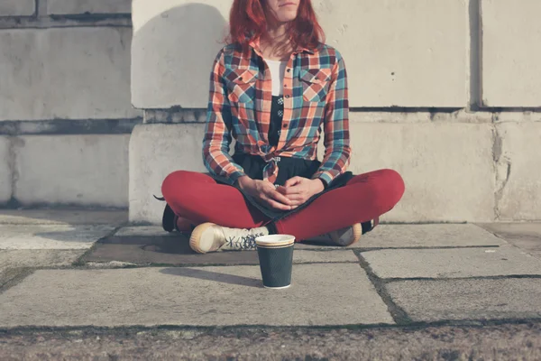 Mujer sentada en la calle con taza de papel — Foto de Stock