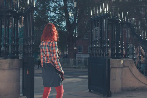 Mujer joven de pie junto a las puertas — Foto de Stock