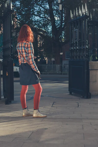 Young woman standing by gates — Stock Photo, Image