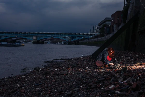 Femeie pieptănând pe plajă în oraș noaptea — Fotografie, imagine de stoc