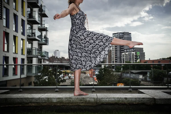 Young woman raising her leg on roof top — Stock Photo, Image