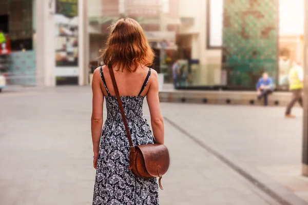 Jonge vrouw lopen in de straat — Stockfoto