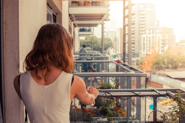 Jonge vrouw ontspannen op haar balkon — Stockfoto