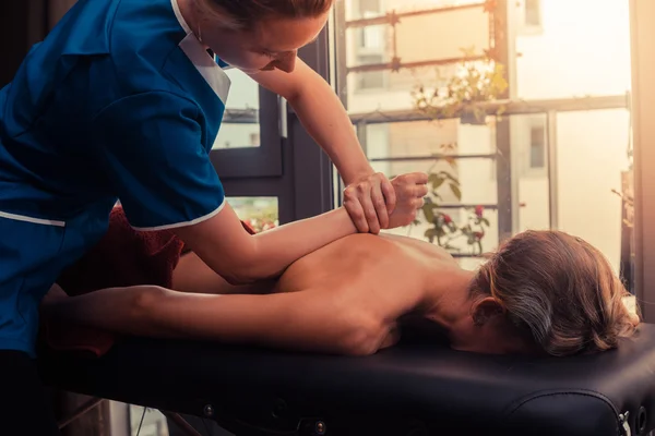 Massage therapist treating a client — Stock Photo, Image
