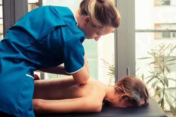 Terapeuta de massagem tratando um cliente — Fotografia de Stock