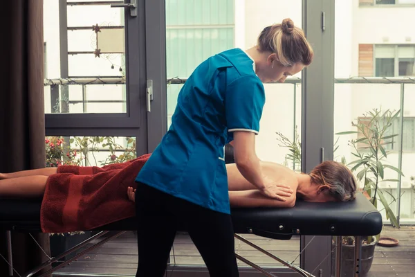 Terapeuta de massagem tratando um cliente — Fotografia de Stock