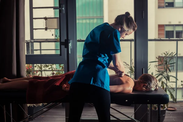 Massage therapist treating a client — Stock Photo, Image