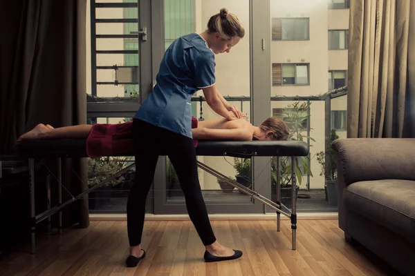 Massage therapist treating patient at home — Stock Photo, Image