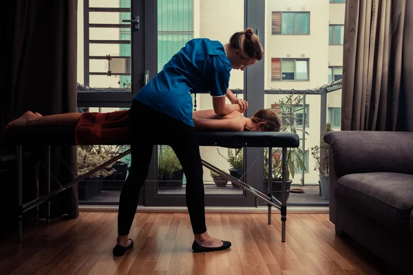 Terapeuta de massagem tratando o paciente em casa — Fotografia de Stock