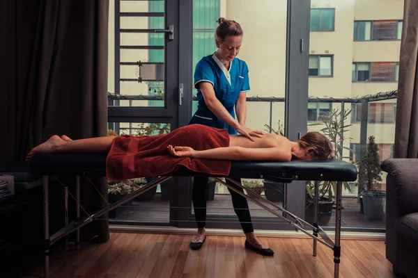 Massage therapist treating patient at home — Stock Photo, Image