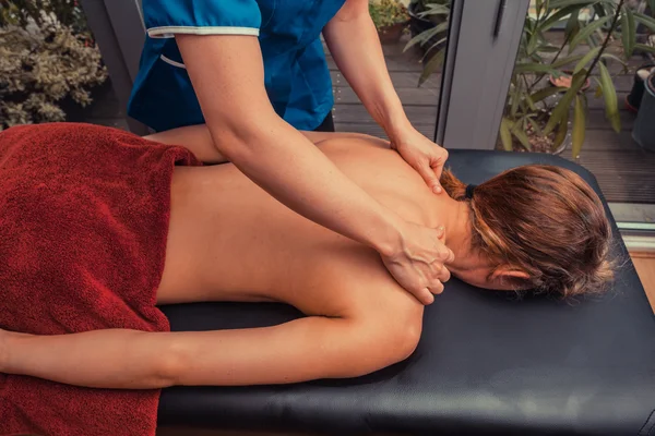 Massage therapist treating patient at home — Stock Photo, Image