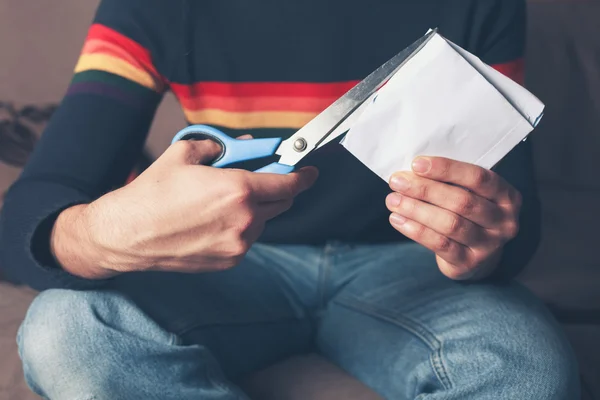 Young man cutting up paper — Stock Photo, Image