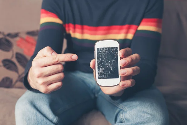 Homem apontando para telefone inteligente quebrado — Fotografia de Stock