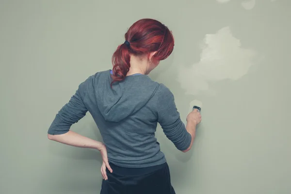 Vrouw schilderij een muur groen — Stockfoto