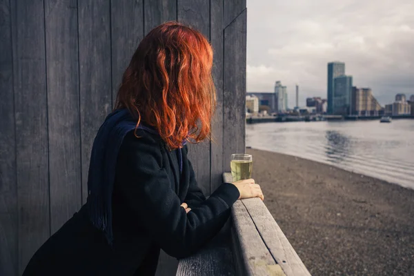 Woman drinking beer by the river — Stock Photo, Image