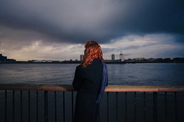 Woman admiring sunet over river in city — Stock Photo, Image