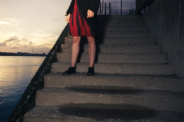 Woman stranding on stairs by river — Stock Photo, Image