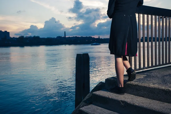 Mujer varada en escaleras por el río — Foto de Stock