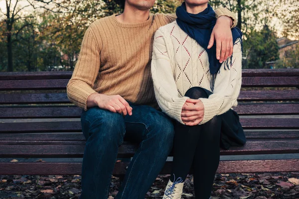 Pasangan muda duduk di bangku taman — Stok Foto