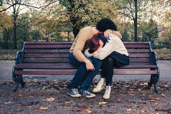 Triste jovem casal no banco do parque — Fotografia de Stock