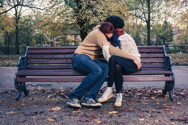 Sad young couple on park bench — Stock Photo, Image
