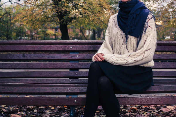 Młoda kobieta siedziała na ławce w parku — Zdjęcie stockowe