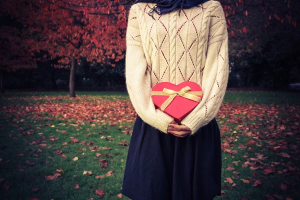 Femme avec boîte en forme de coeur dans le parc — Photo