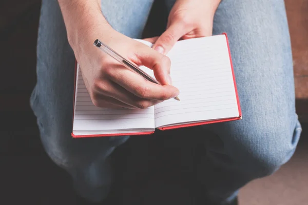 Man die schrijft in notebook — Stockfoto