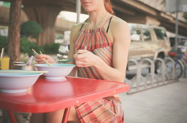 Mujer comiendo fideos en la calle — Foto de Stock