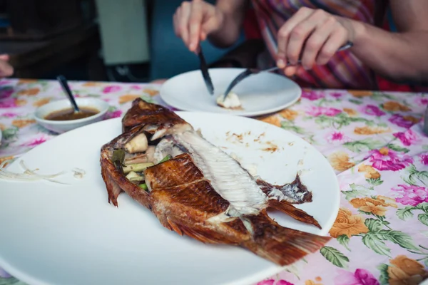 Kvinna äta fisk i restaurang — Stockfoto
