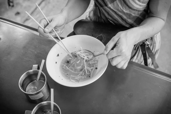 Woman eating noodles in the street — Stock Photo, Image