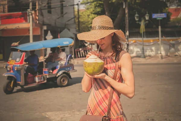 Woman drinking from coconut in the street — Stock Photo, Image