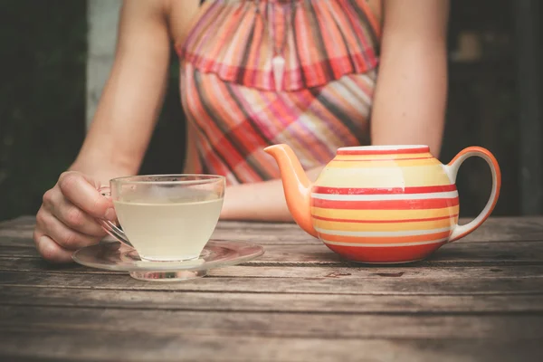 Mujer joven bebiendo té en la mesa —  Fotos de Stock