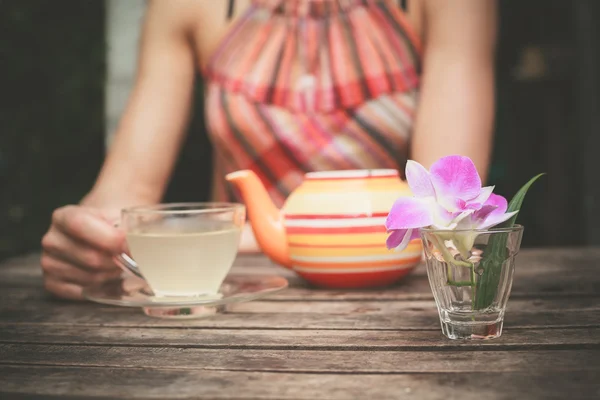 Jovem mulher bebendo chá à mesa — Fotografia de Stock