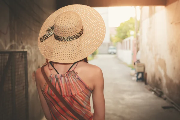 Jonge vrouw in steegje bij zonsondergang — Stockfoto