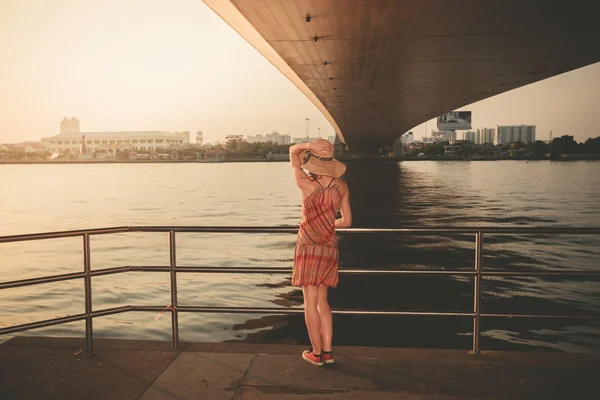 Mujer joven bajo el puente al atardecer — Foto de Stock