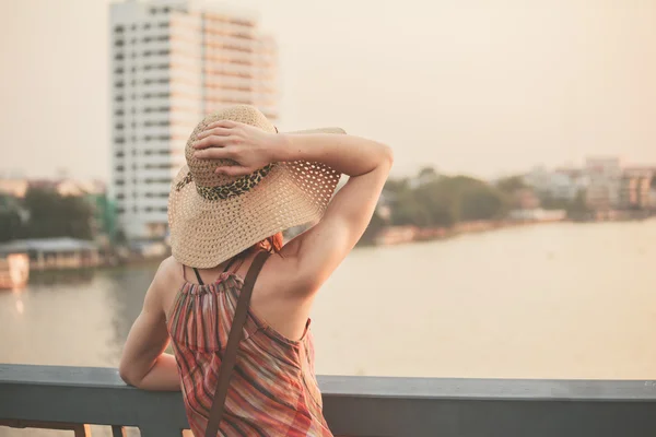 Mujer joven admirando la puesta de sol sobre el río en la ciudad —  Fotos de Stock
