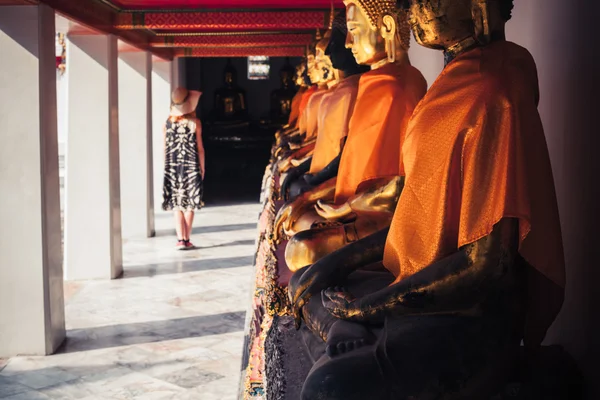 Mujer mirando estatuas de buda en el templo — Foto de Stock